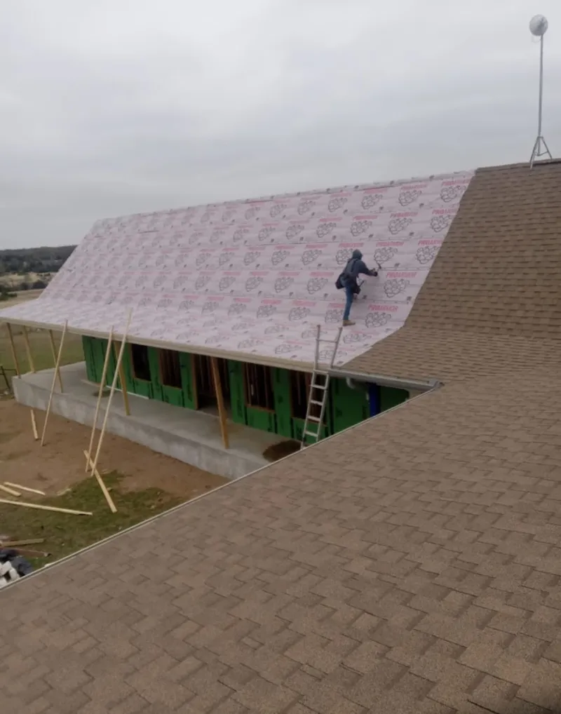 Worker preparing underlayment for a metal roof installation in Tifton